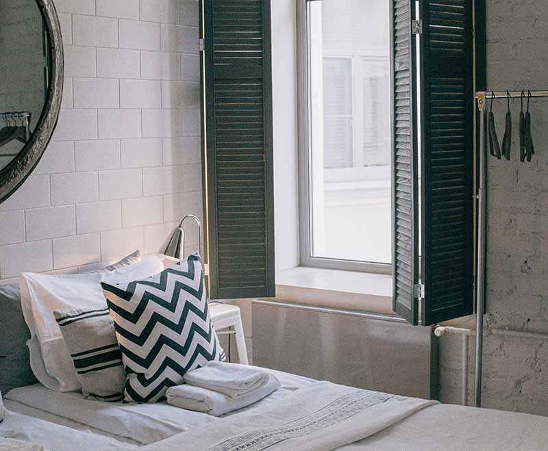 Hotel room with wide-open windows looking at the city streets