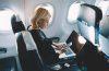 Woman with laptop and mobile phone in the airplane.